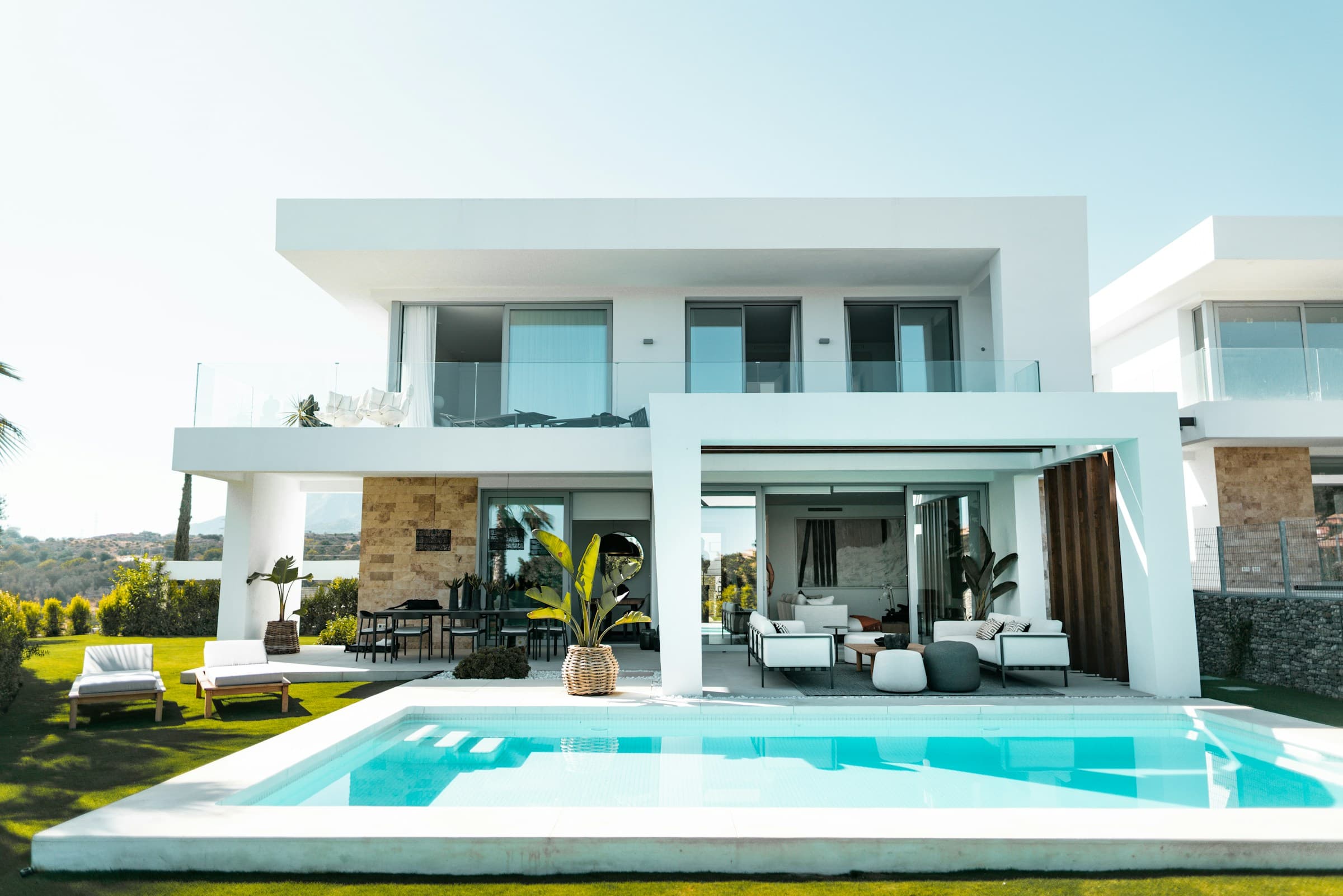 Modern white villa with a turquoise pool and garden