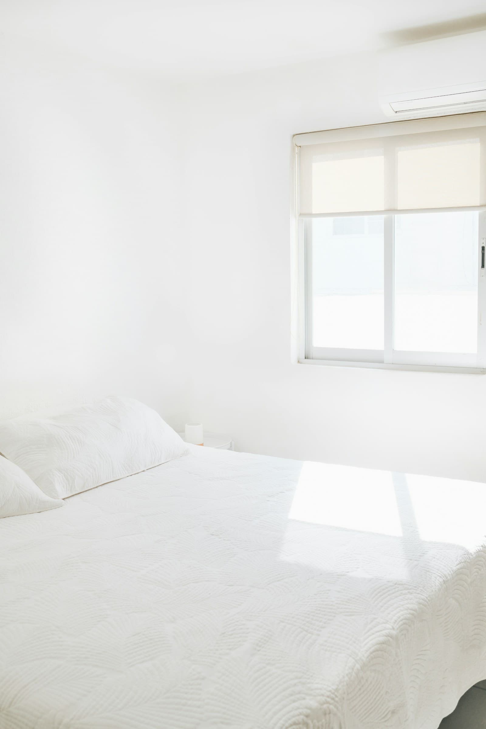 Minimal sunlit white bedroom