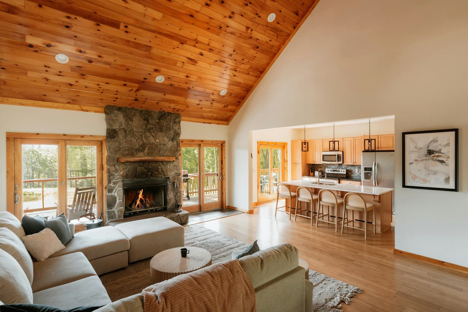 Living room with a stone fireplace and timber ceiling